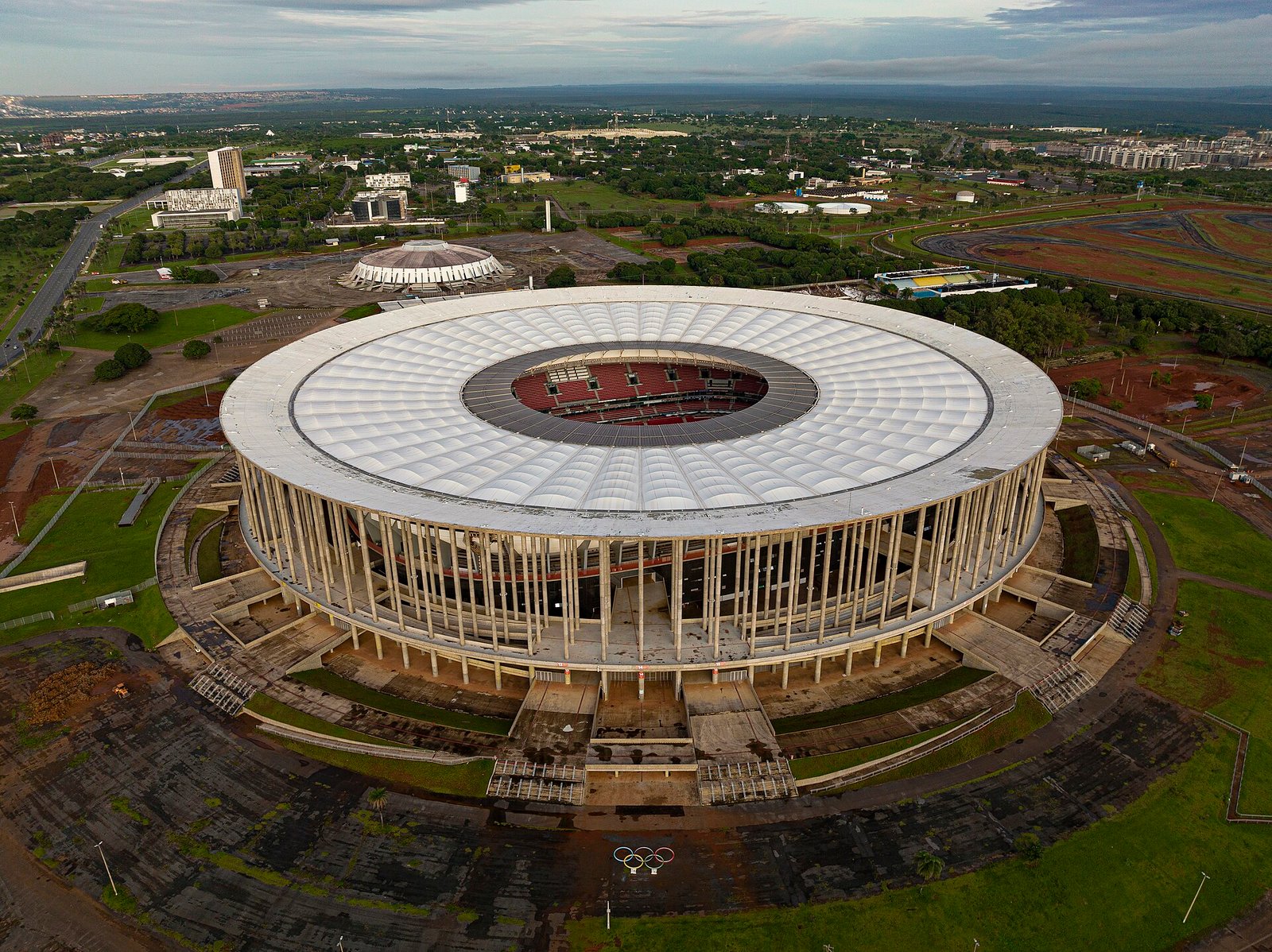 Vista aérea do Estádio Nacional Mané Garrincha, em Brasília, com a cobertura branca e a cidade ao fundo