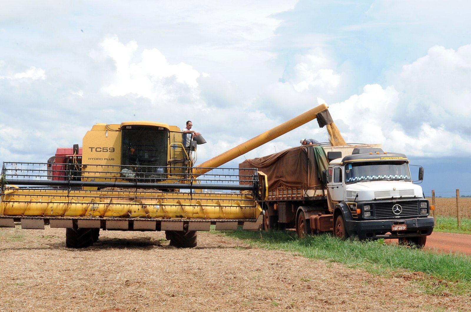 Colheitadeira despeja grãos de soja em caminhão graneleiro durante colheita em fazenda de Rondonópolis, no Mato Grosso
