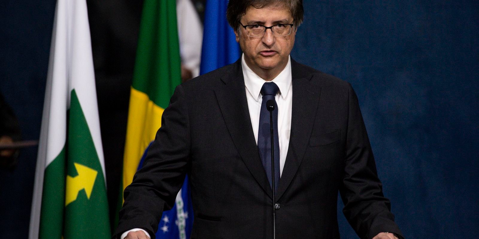 O procurador-geral da Republica, Paulo Gonet, ao microfone diante das bandeiras do Brasil e do MPF