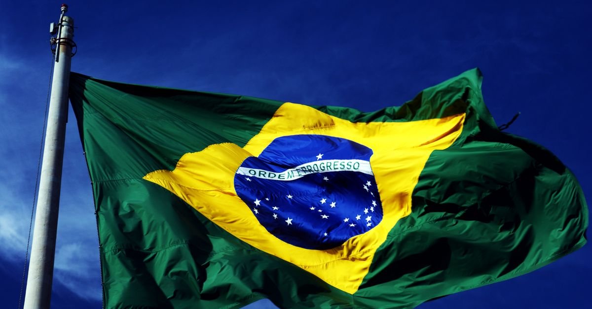 Bandeira do Brasil tremulando em mastro contra o céu azul