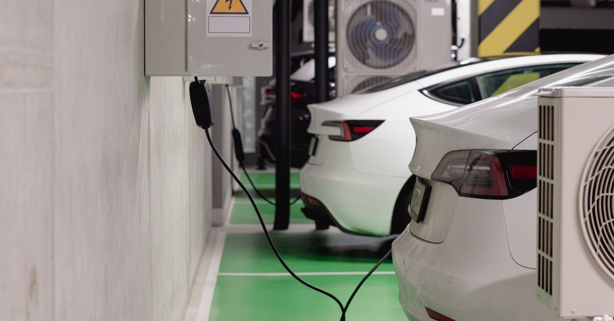 Carros elétricos conectados a ponto de recarga em garagem