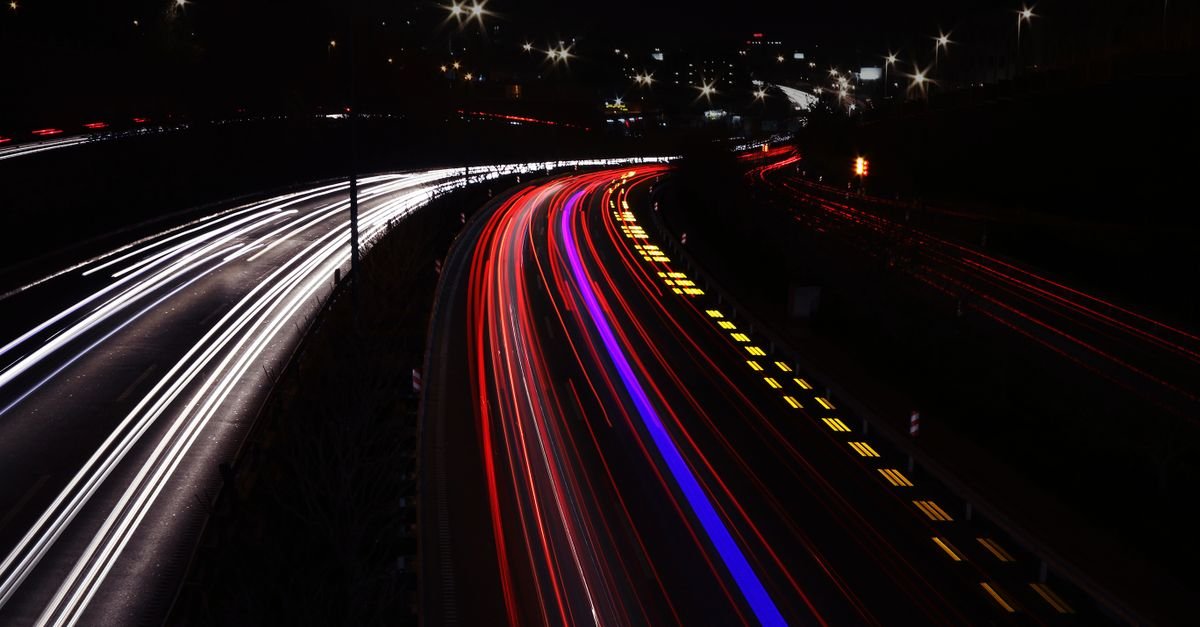Rastros de luz de veículos em rodovia à noite, em longa exposição