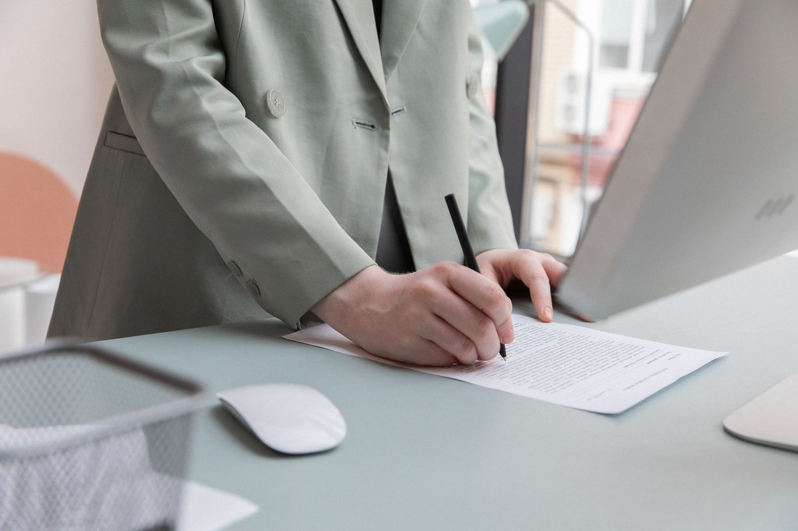 Pessoa assina contrato de trabalho sobre mesa de escritório (foto ilustrativa)