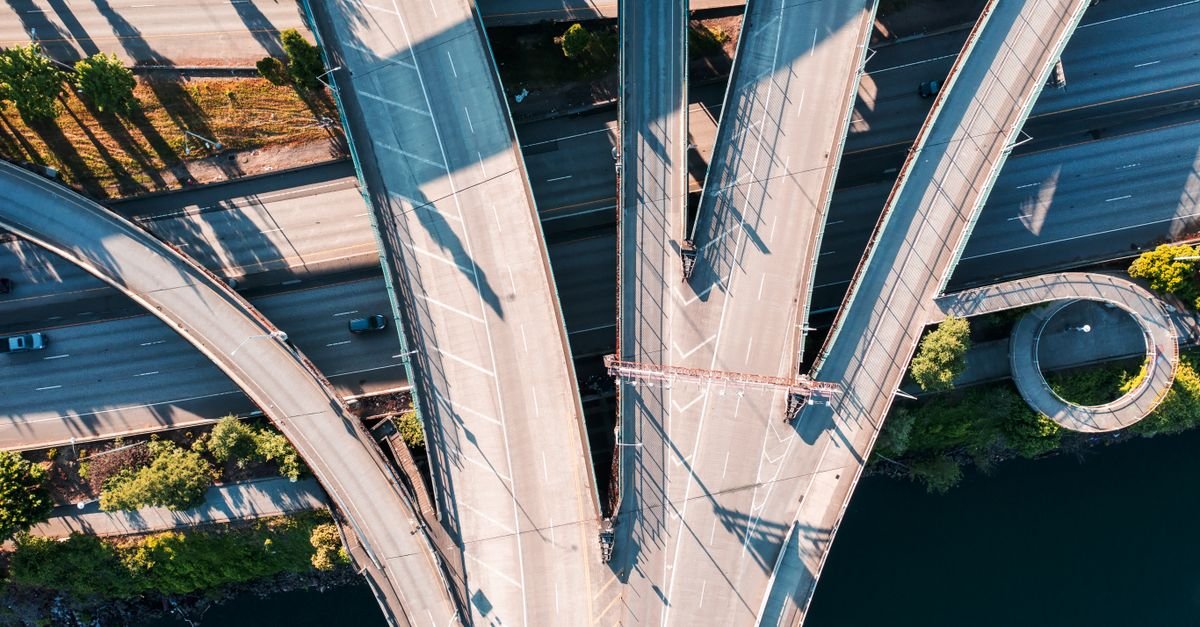 Vista aérea de um entroncamento rodoviário com viadutos sobrepostos e faixas de rolamento