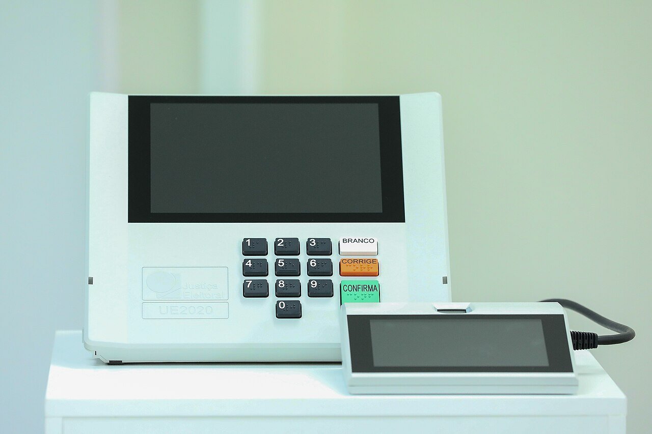 Urna eletrônica brasileira modelo UE2020, com teclado numérico e teclas branco, corrige e confirma