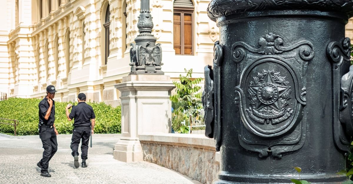 Dois seguranças privados em patrulha a pé em frente a prédio histórico