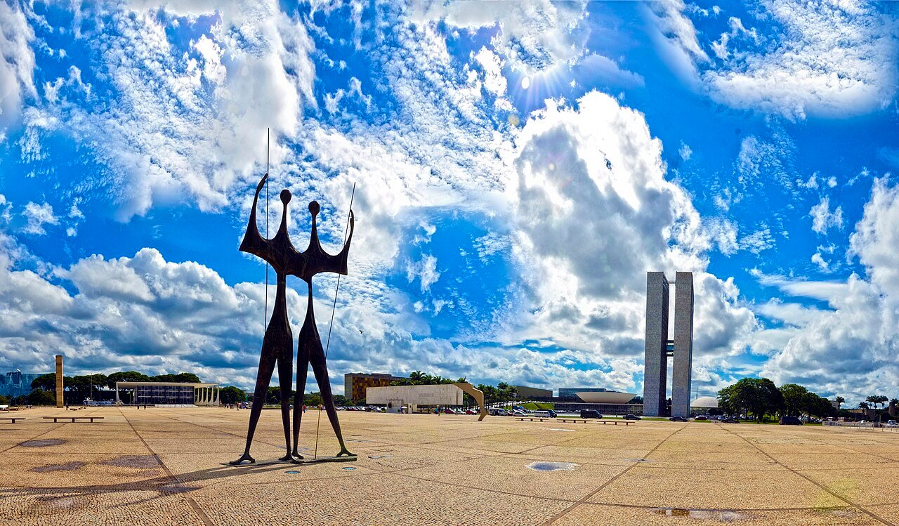 Escultura Os Candangos na Praça dos Três Poderes, com as torres do Congresso Nacional ao fundo