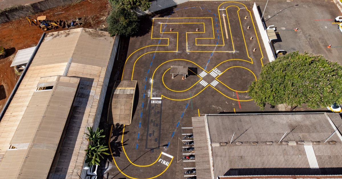 Vista aérea de pista de treinamento de autoescola com marcações amarelas e as palavras início e final pintadas no asfalto