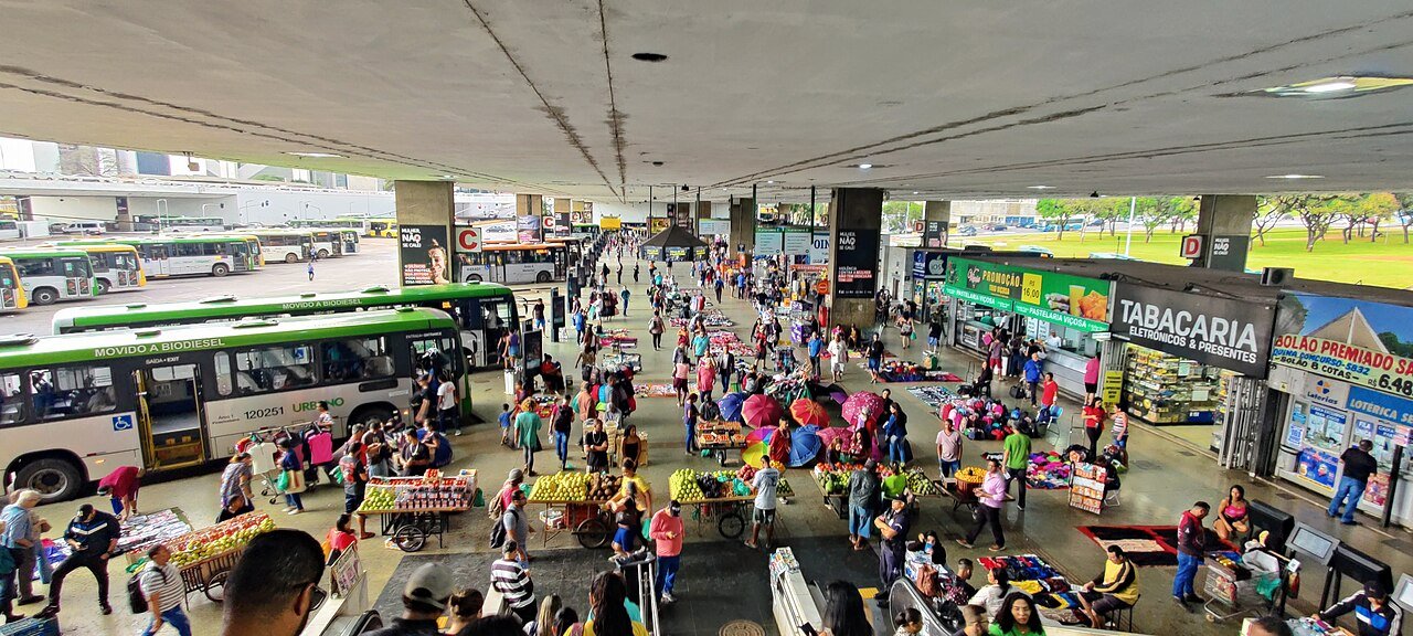 Plataforma da Rodoviária do Plano Piloto com ônibus, comércio e movimento de passageiros