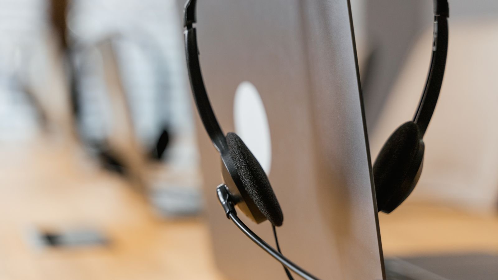Fone de headset de atendimento pendurado em um notebook, imagem ilustrativa