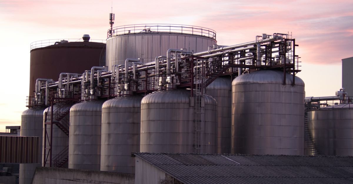 Tanques de armazenamento de uma refinaria de combustíveis ao entardecer