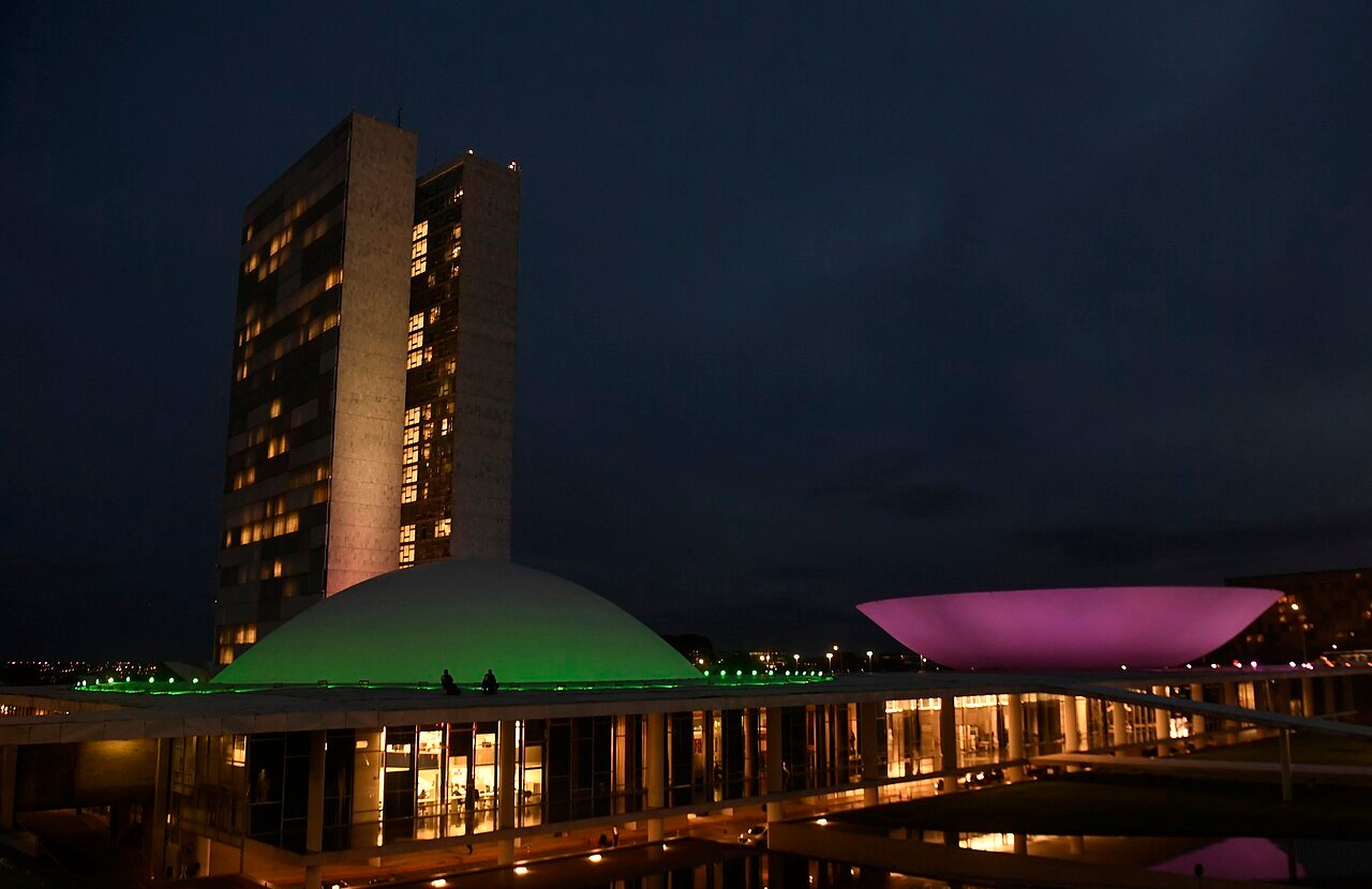 Edifício do Congresso Nacional iluminado ao anoitecer, em Brasília