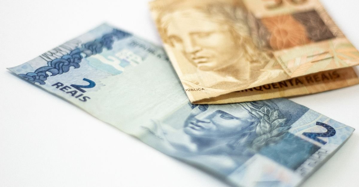 Cédulas de 2 e 50 reais sobre superfície branca, em referência aos recursos das emendas parlamentares