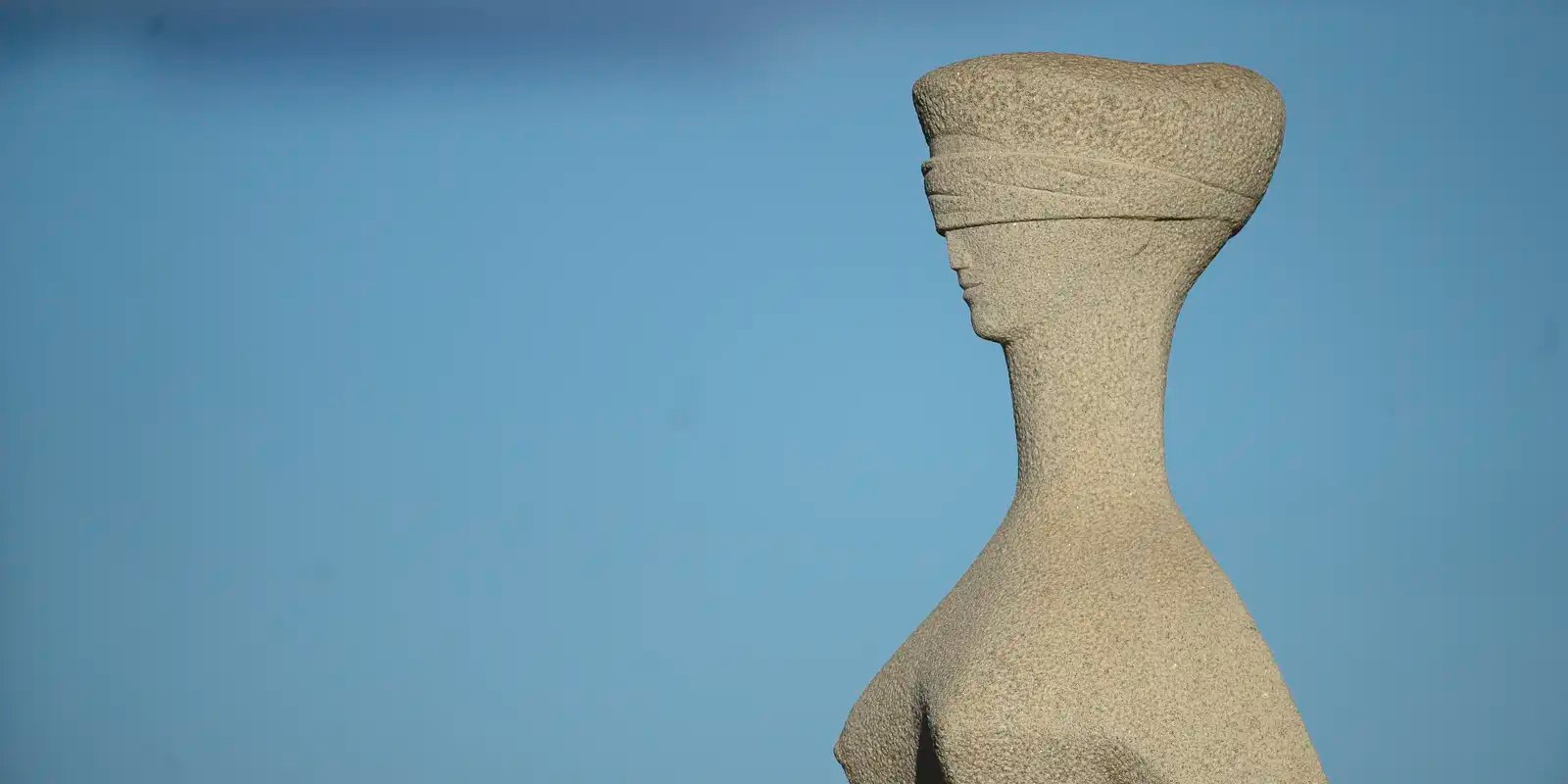 Detalhe da estátua A Justiça, de olhos vendados, em frente ao Supremo Tribunal Federal, contra o céu azul; foto de arquivo