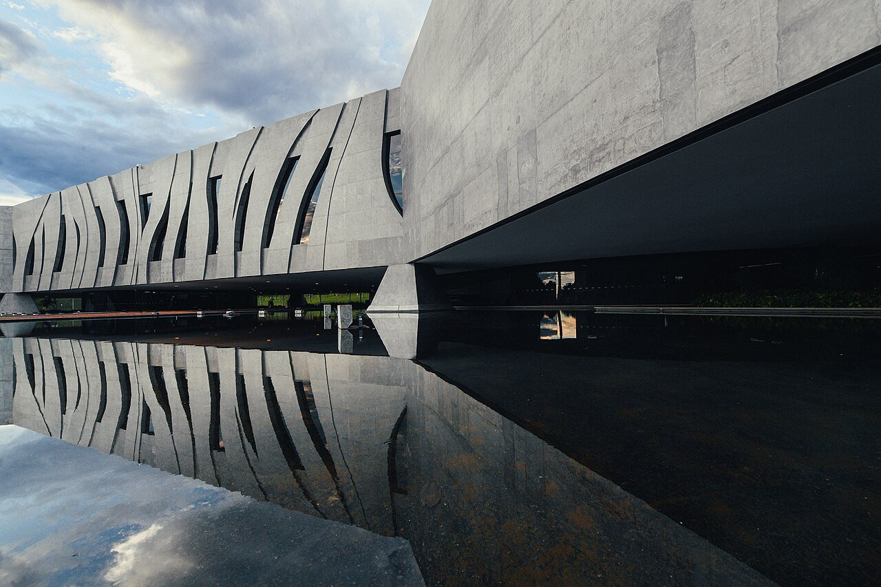 Fachada de concreto do edifício-sede do Superior Tribunal de Justiça, em Brasília, refletida no espelho d água