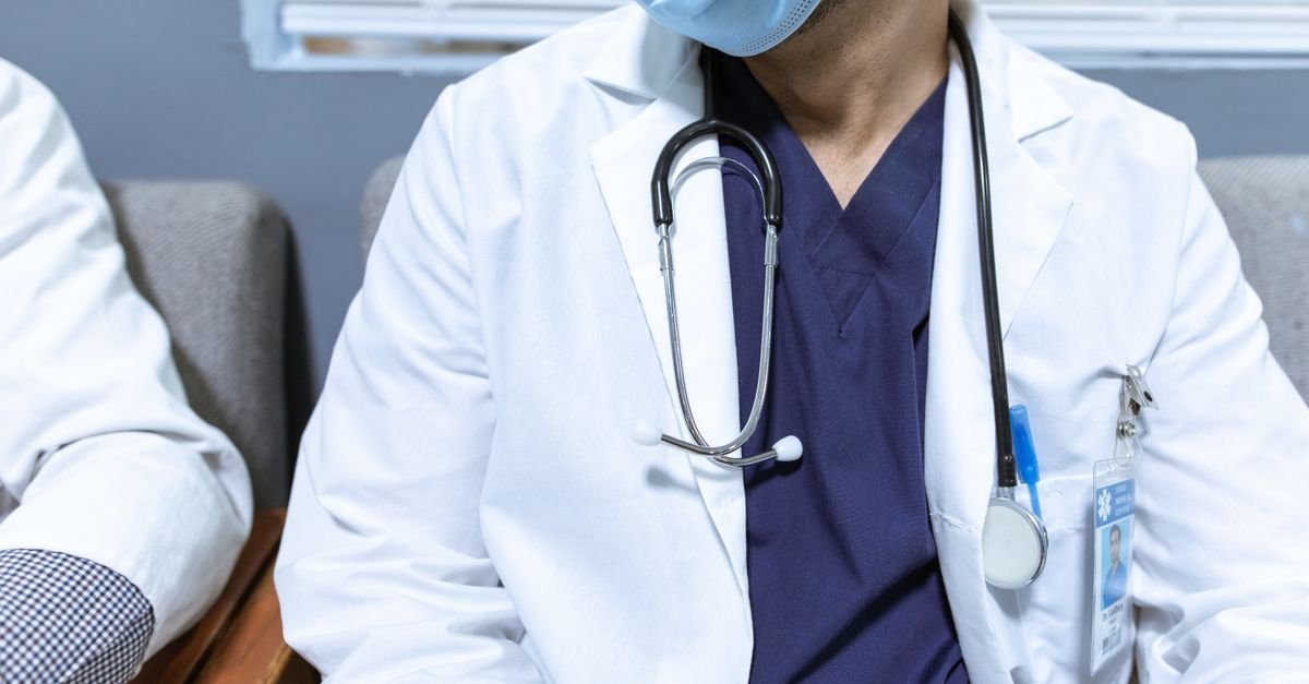 Profissional de saúde de jaleco branco com estetoscópio no pescoço
