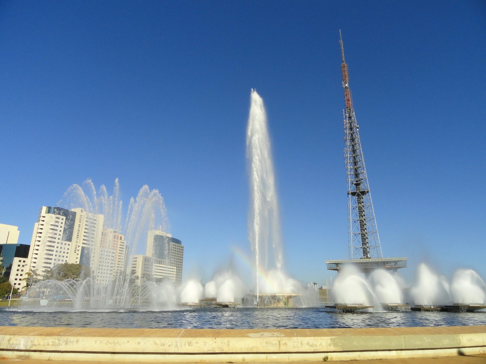 Fontes luminosas e a Torre de TV de Brasília sob céu azul