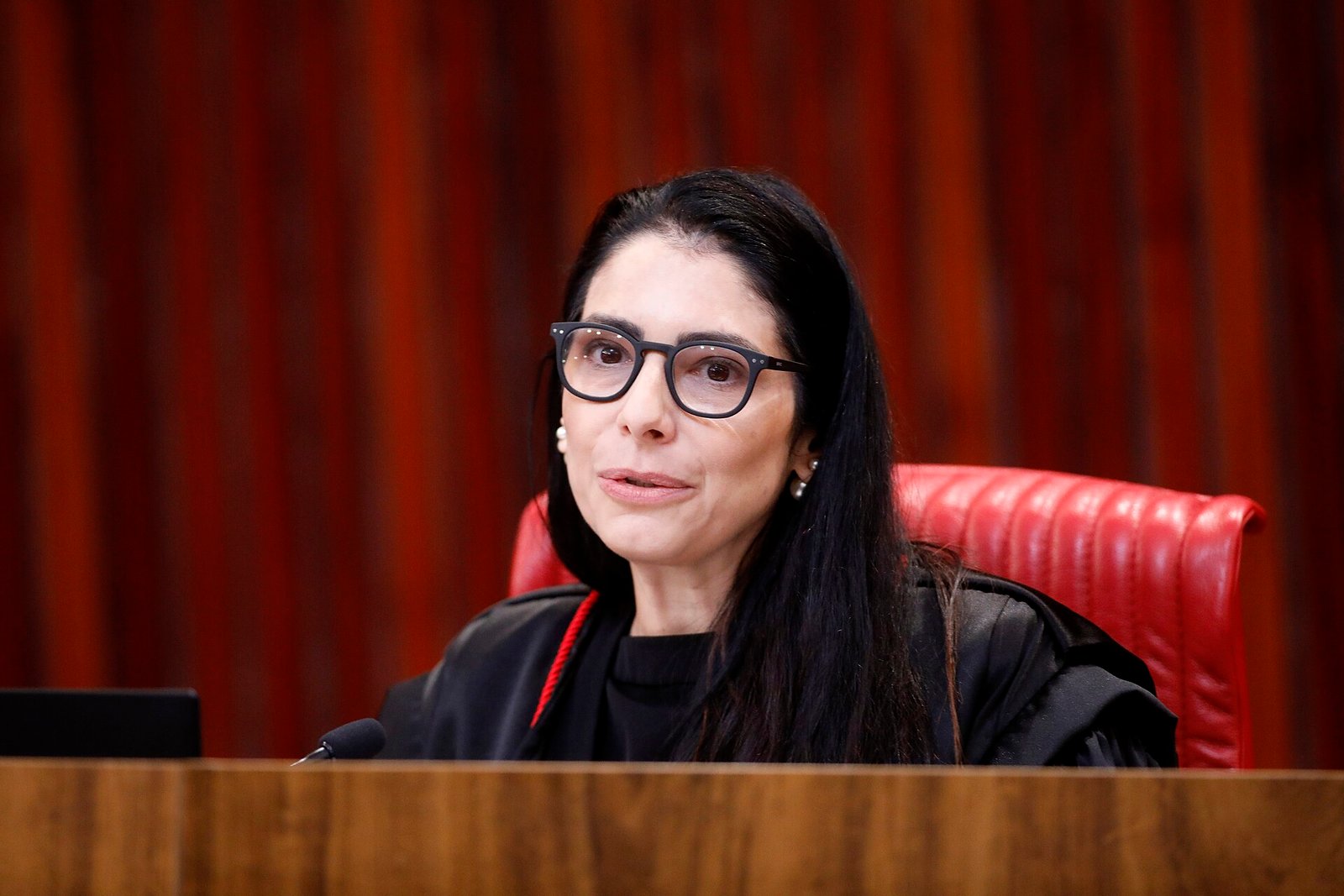 Ministra de toga preta fala ao microfone no plenário do Tribunal Superior Eleitoral