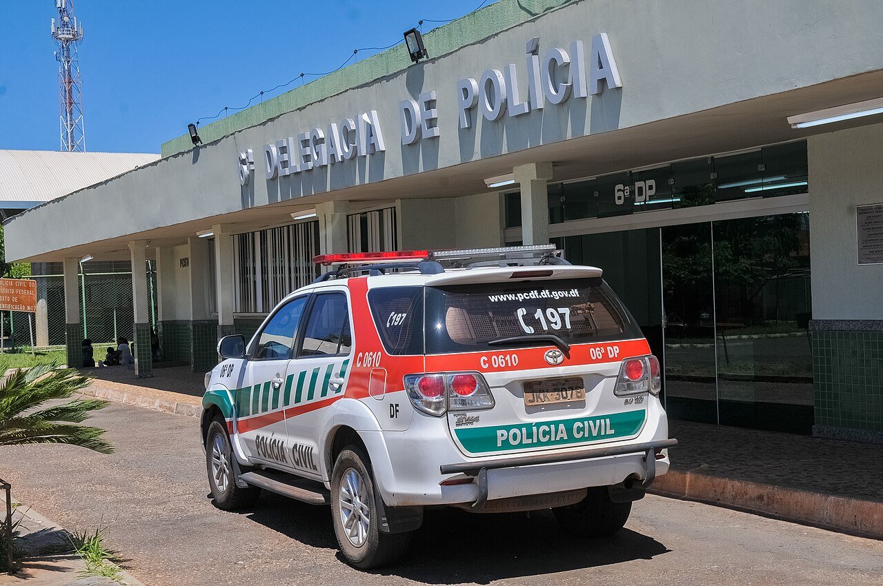 Viatura da Polícia Civil do Distrito Federal estacionada em frente à fachada de uma delegacia de polícia