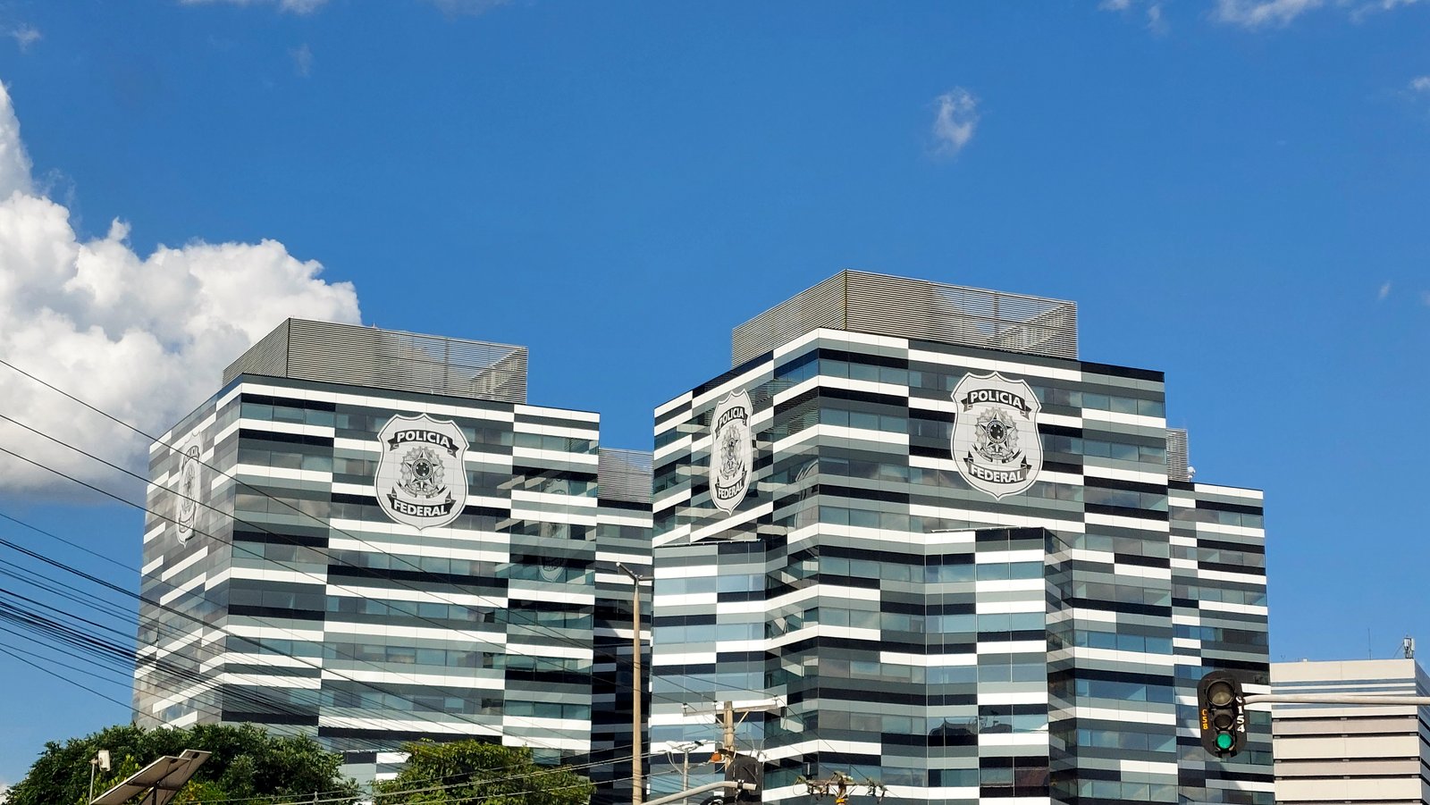 Fachada da sede da Polícia Federal em Brasília, com o brasão da instituição nas duas torres
